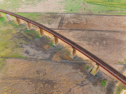 Looking down on a raised railway viaduct over farmland