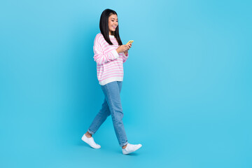 Fototapeta na wymiar Full body size photo of young freelancer attractive japanese woman hold phone browsing new information online isolated on blue color background