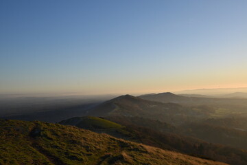 Naklejka na ściany i meble the top of the Malvern hills on a misty day during sunset