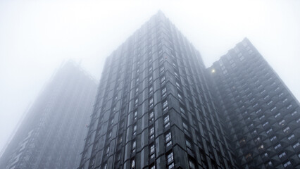 Exterior shot of the top of high rise buildings on a cloudy and foggy day