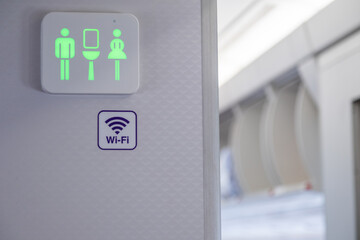Green sign of lavatory in the airplane during fly.