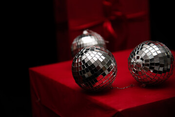 silver mirror balls on red gifts and black background