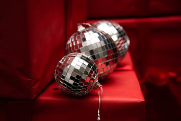 silver mirror balls on red gifts and black background
