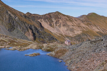 Alpine mountain hut by the lake, summer