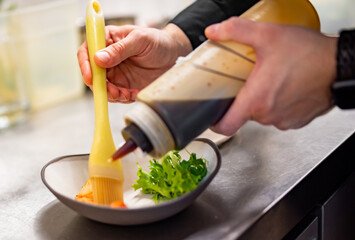 chef cooking slice salmon fish and shrimp with salad on kitchen