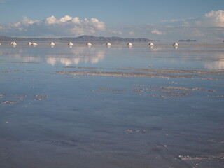 ウユニ塩湖の塩と反射する雲