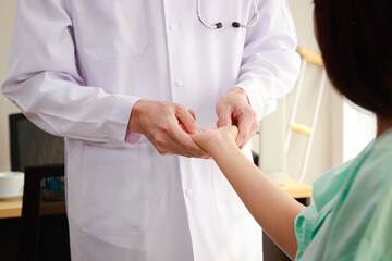 Asian doctors massage the palm of the hand to a patient who is hospitalized. Massage to relieve...