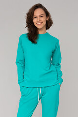 Smiling woman with thick curly hair in a mint suit of hoodies and sweatpants. Mock-up.