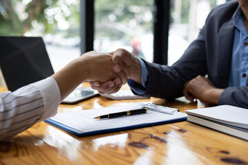 Businessmen shaking hands after reaching legal contract agreement.