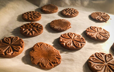 close up of pressed gingerbread cookies baking in the oven on parchment paper
