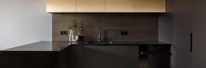 Elegant black and gold kitchen, panorama