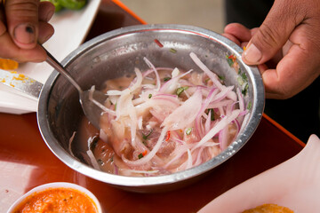 Preparing a delicious Peruvian sea bass ceviche in the fishing port of Chorríos in Lima.