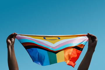 holding an intersex-inclusive progress pride flag - obrazy, fototapety, plakaty