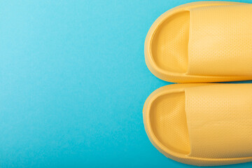 Bright rubber slippers on a blue background. Summer slates. Indoor shoes. Place for text. FLAT LAY