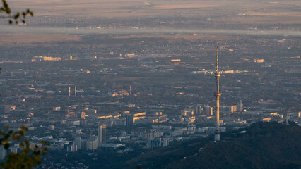 Obraz premium TV tower on the background of the city. a city at the foot of the mountains
