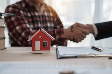 Shaking hands, Credit approver, businessman in male suit and house toy model mockup Home loan mortgage approval concept. After signing the contract