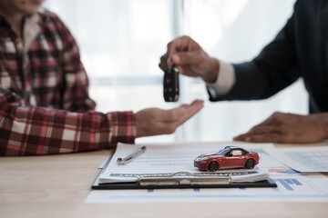 Loan approver, businessman in suit, man giving car keys after car loan approval and contract signing