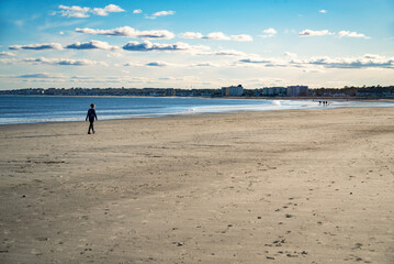 A woman walking on a beach in Maine in the wintertime