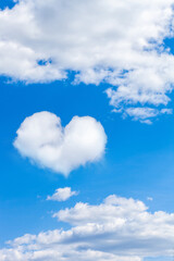 Naklejka na ściany i meble clouds on a blue sky with a heart shaped cloud. vertical frame