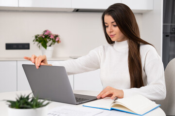 Smart pretty young woman opens laptop for study online at home