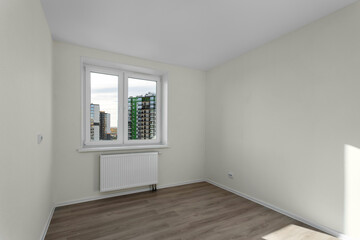 Bright room with sun rays after renovation with a view of the houses in the window 