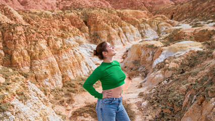 Caucasian woman stands on a clay hill.