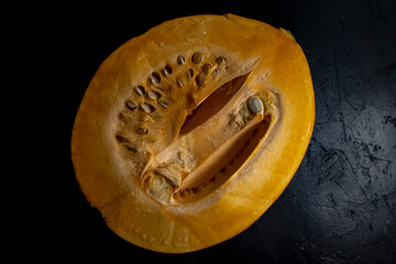 Half of a pumpkin on a black background, top view of a cut pumpkin