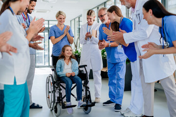 Medical staff clapping to little girl patient who recovered from serious illness.
