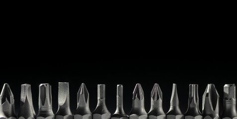 Set of heads for screwdrivers (bits) . On a black isolated background. Place for text. Close-up .