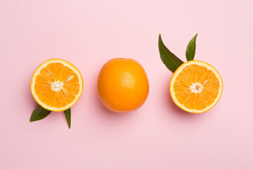Flat lay with fresh oranges and leaves on color background