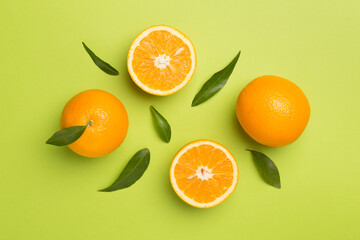 Flat lay with fresh oranges and leaves on color background