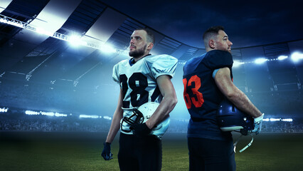Two american football player in uniform standing back to back in uniform isolated on stadium background with flashlights. Winners