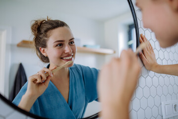 Young woman brushing her teeth, morning routine concept.
