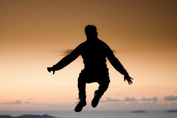 Fototapeta na wymiar silhouette man jumping at sunset