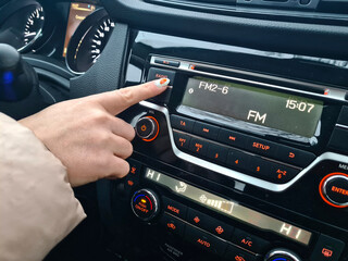 Girl chooses a radio station in the car.