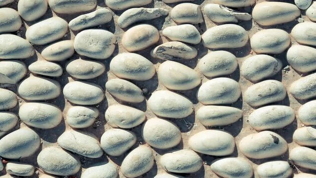 Stones pattern background seamless loop. Lot of white masonry cladding pebble texture.