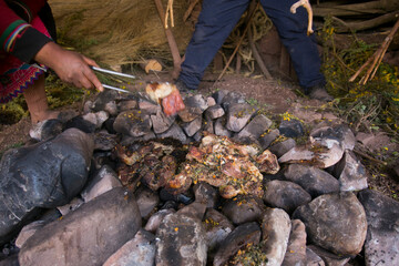 Fototapeta premium In the pachamanca ceremony, lamb, alpaca, pork and beef are cooked. Also variety of tubers and vegetables. All under hot stones and covered with earth.