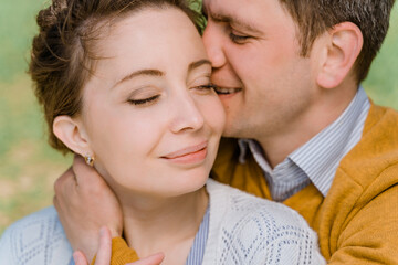 close-up of a man and woman gently hugging and kissing, eyes closed