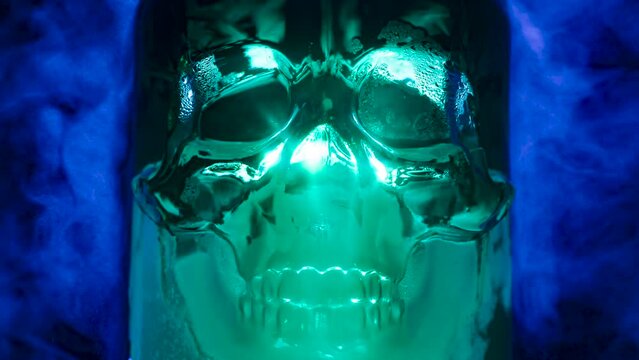Poisonous Chemistry. Glass skull of bluish glass on a background of poisonous blue smoke