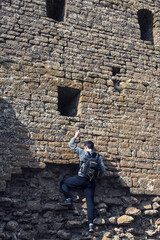 Man climbing a stone wall