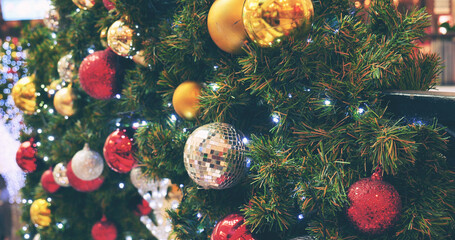 Fototapeta na wymiar Colourful glittering baubles ornament ball decorated christmas tree on holiday winter xmas happy new year festival celebration. Red, gold, silver ball on Christmas tree. Merry Christmas happy new year