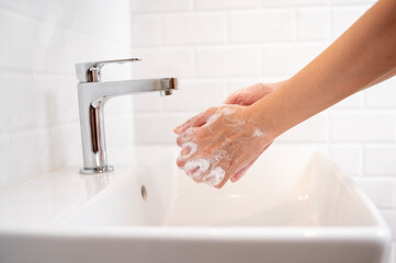 Woman washing her hands  in the bathroom at home