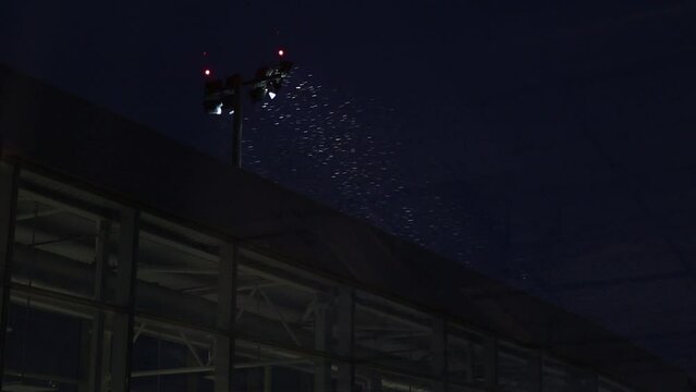 Snow is flying in front of the light at night