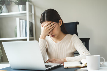 Stress young asian woman covering her face and exhausting overworked at home office.