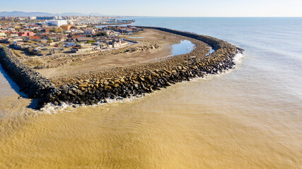Aerial view of a polluted stretch of coast. The sea water is dirty and yellow. Pollution concept.