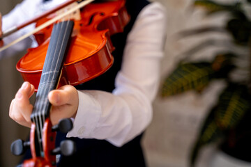 a girl in a beautiful white blouse with a frill and a blue skirt plays the violin, holds bows in...