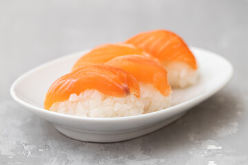 Japanese cuisine. Salmon sushi nigiri on a white plate