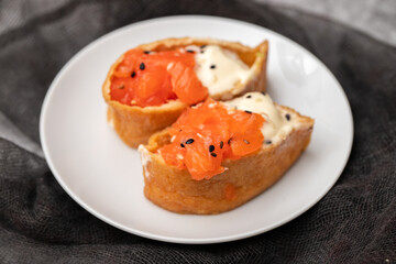 Japanese cuisine. Salmon sushi nigiri on a white plate