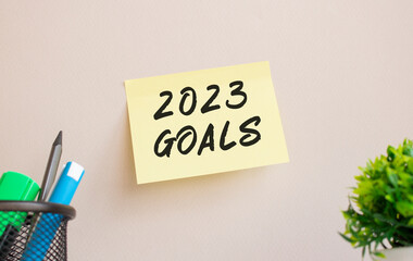 The sticker is glued to the wall in the office. There is a reminder on the sticker. 2023 GOALS text is handwritten.