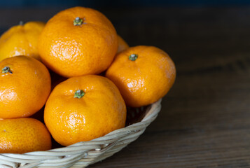 Small tangerines, thick and soft rind, easy to peel, seedless, sweet tropical fruit in bamboo baskets, ready to eat.